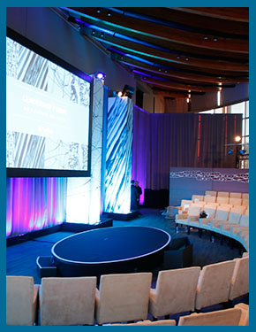 Photo of a modern conference room with stage and large screen, a stunning event held at UC San Diego's Great Hall