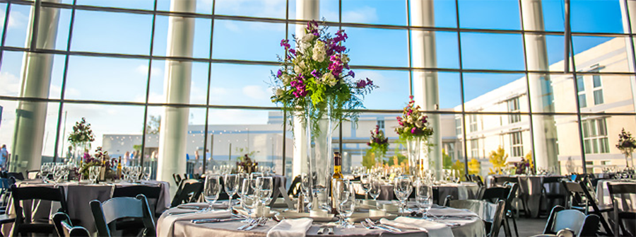 UC San Diego's Great Hall interior, with special event table setup and dramatic floral centerpiece