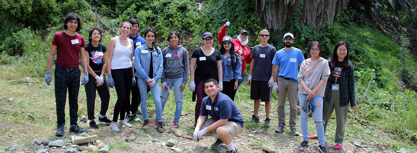 A large group of UC San Diego International House students pose for a photo while taking a hike outdoors