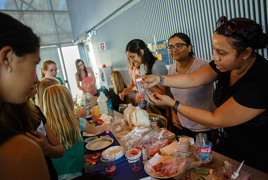 I-Plus event - students gather around the buffet table in the Great Hall, International House, UC San Diego