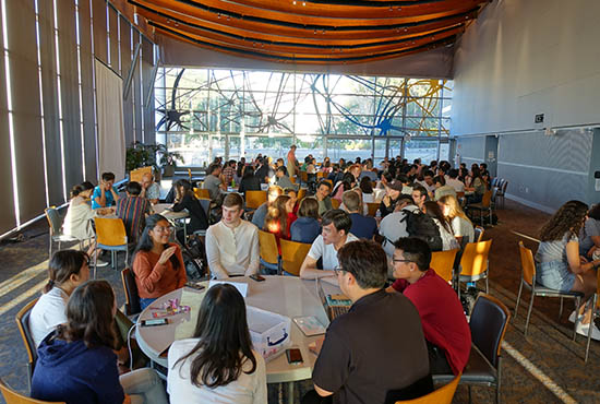 Language Conversion Tables full of students and community members, inside the Great Hall, International House, UC San Diego